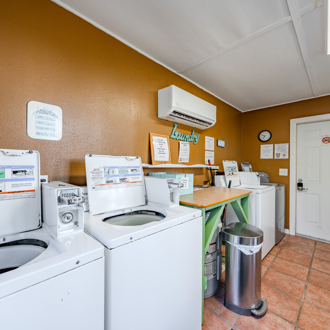 Interior shot of the laundry facility, showcasing 3 washing machines and a folding table
