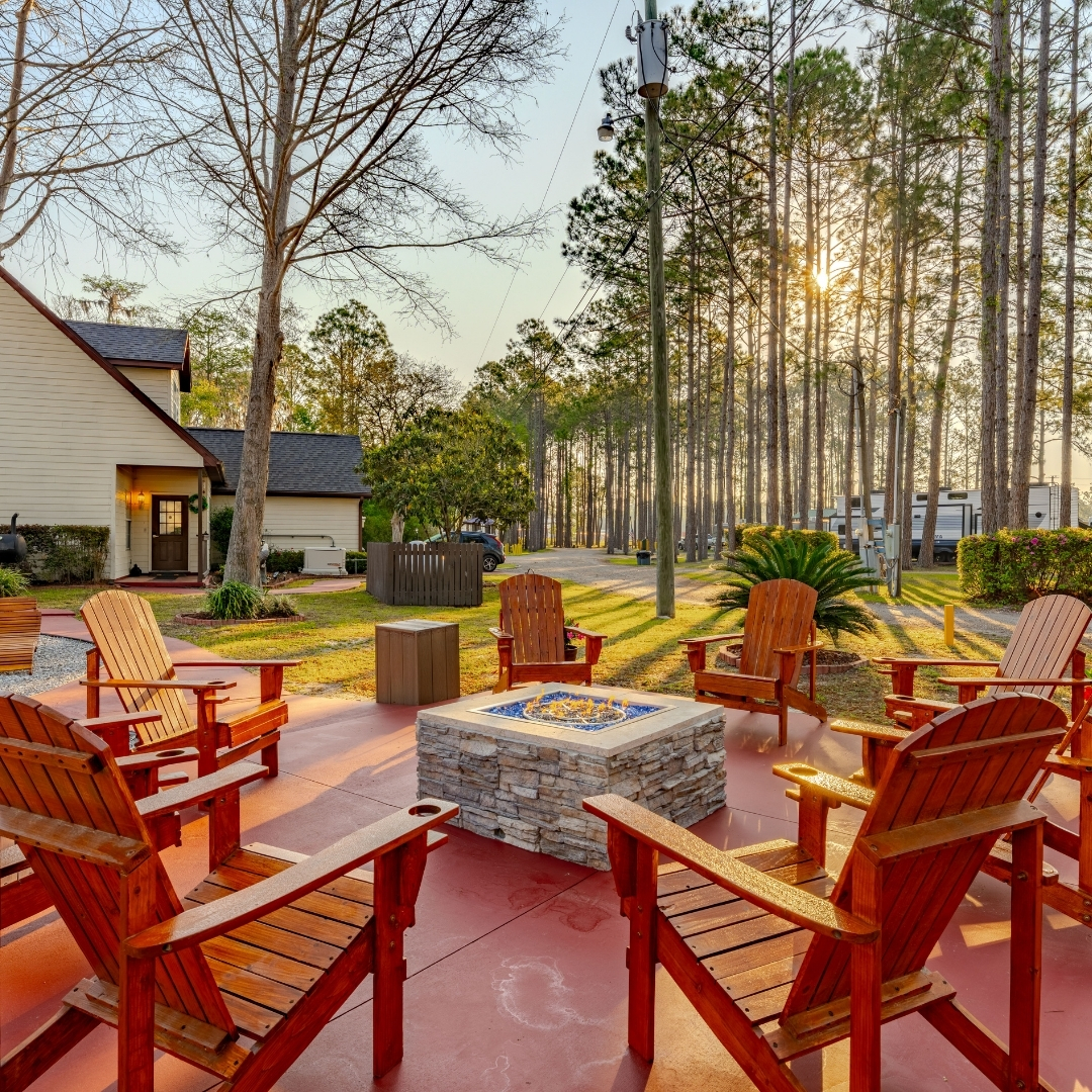 Chairs around a fire pit at sunrise, with light shining through the trees