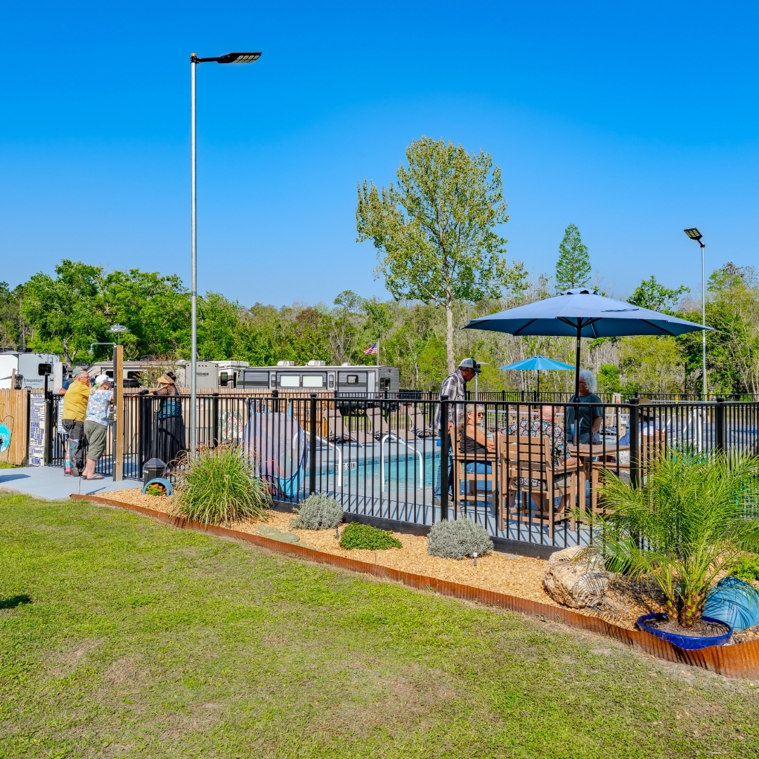 outdoor pool with patio furniture on a sunny day at Lake City RV Resort