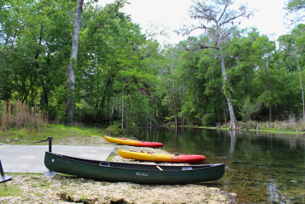 Photo of canoes resting on the shores of a body of water at Ichetucknee Springs